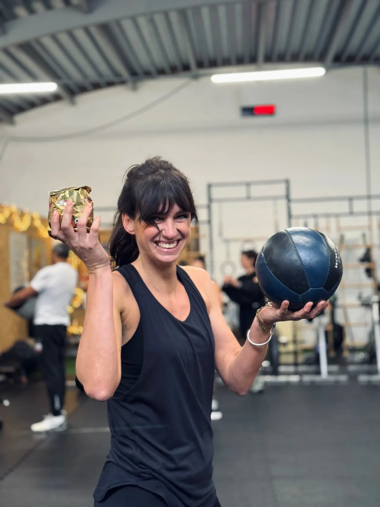 Lachend lid van Bootcamp Huissen met een medicijnbal in De Loods.