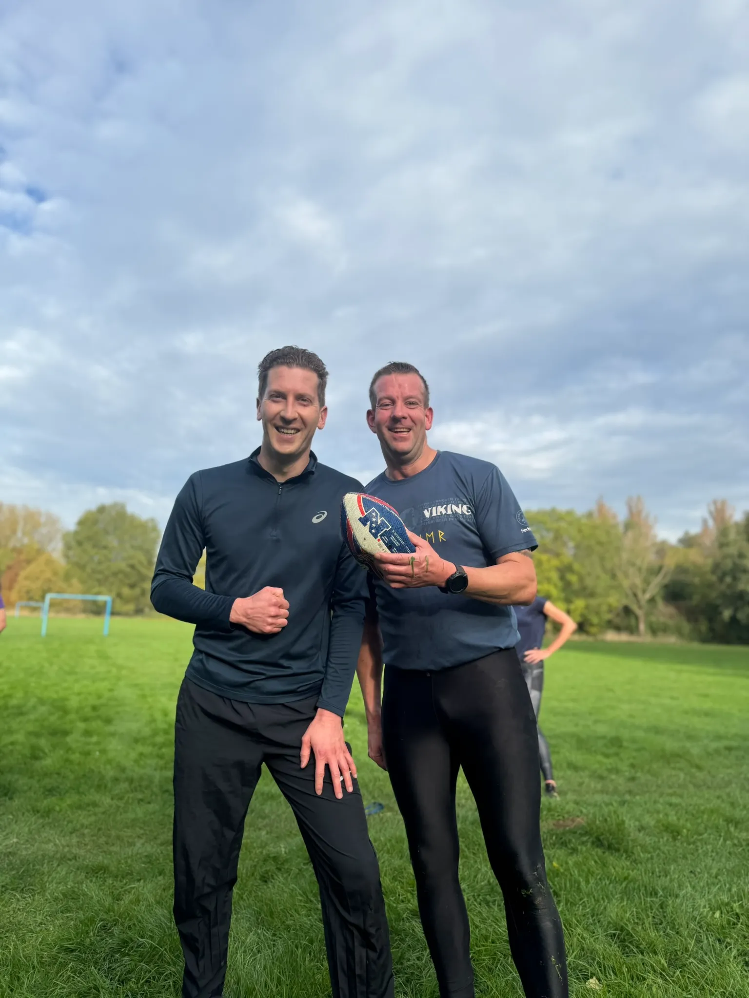Deelnemers aan Bootcamp Outside die samen met zandzakken trainen in de buitenlucht